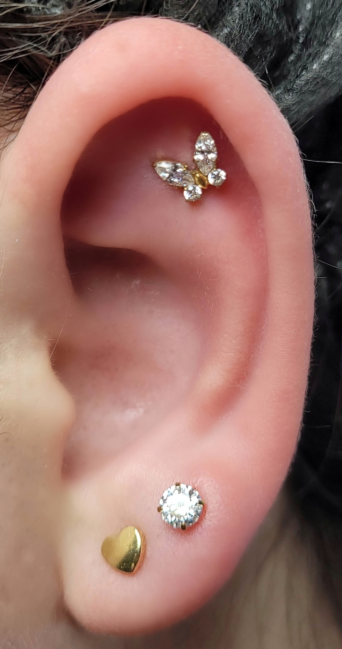 Borboleta cravejada na hélix e ponto de luz no lóbulo