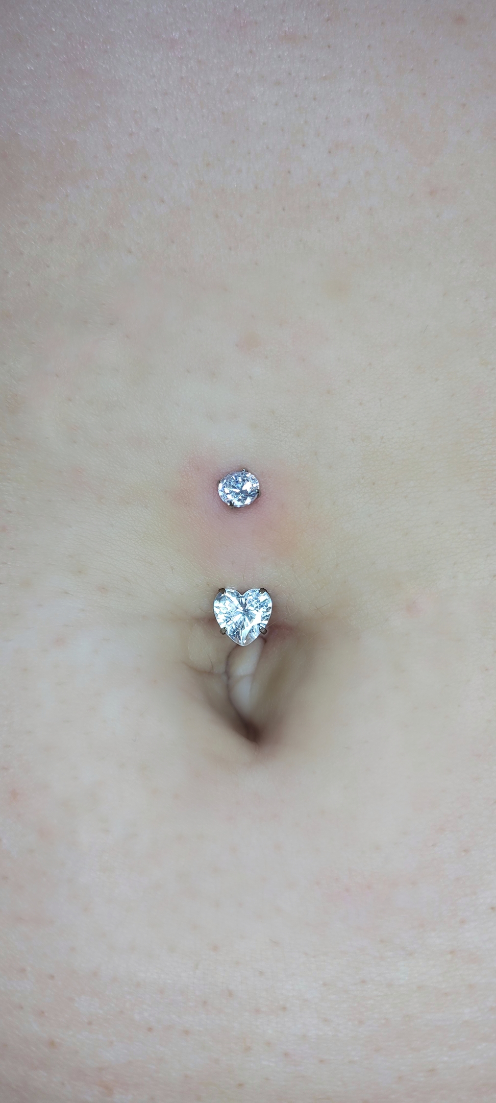 Piercing de umbigo com coração cravejado